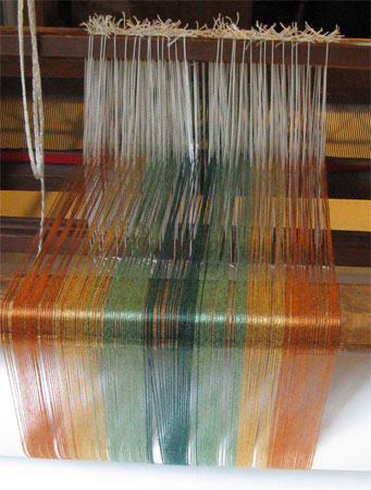 rayon threads on back beam of loom