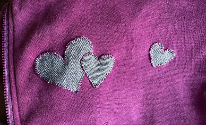 denim heart patches on a purple sweatshirt